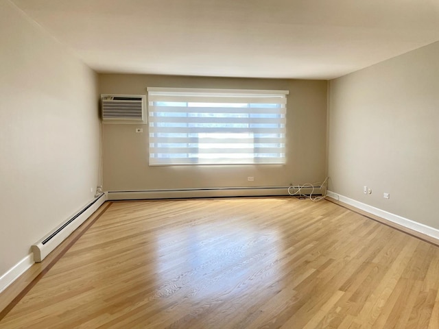 1258 Brown St Unit 302, Des Plaines, IL 60016 - spare room featuring an AC wall unit, baseboard heating, light wood-style flooring, and baseboards