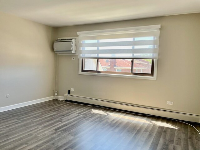1258 Brown St Unit 302, Des Plaines, IL 60016 - empty room with baseboard heating, wood finished floors, a wall mounted AC, and baseboards