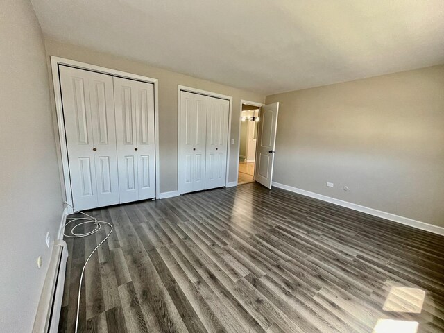 1258 Brown St Unit 302, Des Plaines, IL 60016 - unfurnished bedroom featuring baseboards, two closets, and dark wood-style floors