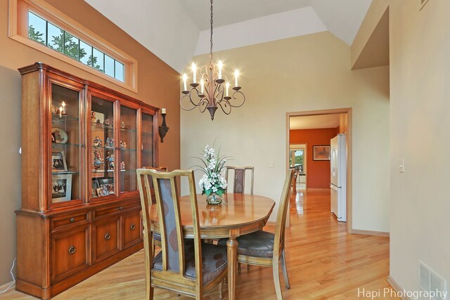 209 S Emerald Dr, Mchenry, IL 60051 - dining space featuring light wood-style flooring, a chandelier, baseboards, and high vaulted ceiling