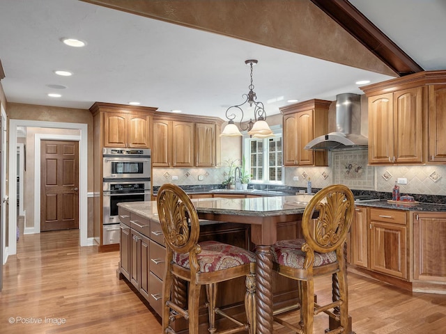 6 Swaps Ct, Oak Brook, IL 60523 - kitchen with wall chimney exhaust hood, stainless steel double oven, a center island, a breakfast bar area, and dark stone counters