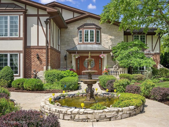 6 Swaps Ct, Oak Brook, IL 60523 - tudor house featuring a small pond, stucco siding, stone siding, and brick siding