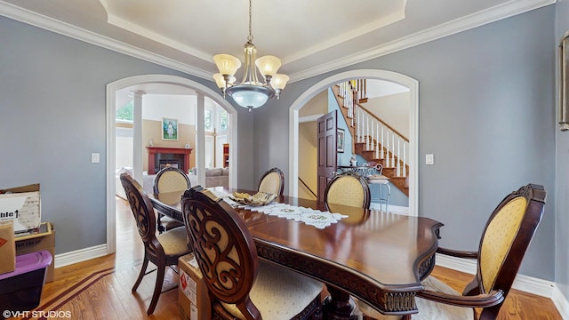 17040 Cheyenne Ct, Lockport, IL 60441 - dining space with arched walkways, a chandelier, a raised ceiling, wood finished floors, and ornamental molding