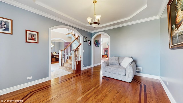 17040 Cheyenne Ct, Lockport, IL 60441 - living area with arched walkways, a raised ceiling, a chandelier, wood finished floors, and stairway