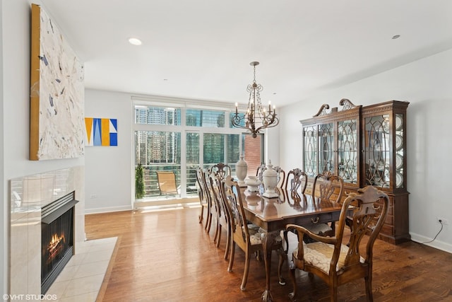 415 E N Water St Unit 2203, Chicago, IL 60611 - dining room featuring a chandelier, baseboards, light wood finished floors, a tile fireplace, and recessed lighting