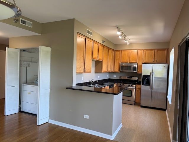 100 N Hermitage Ave Unit 409, Chicago, IL 60612 - kitchen with appliances with stainless steel finishes, a sink, washer / dryer, and wood finished floors