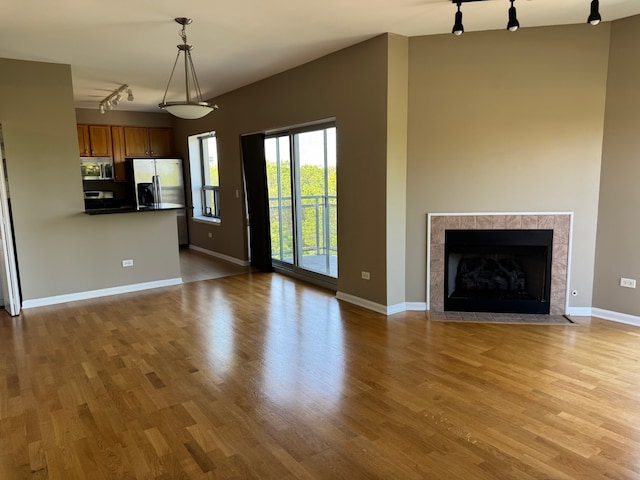 100 N Hermitage Ave Unit 409, Chicago, IL 60612 - unfurnished living room featuring track lighting, wood finished floors, baseboards, and a fireplace
