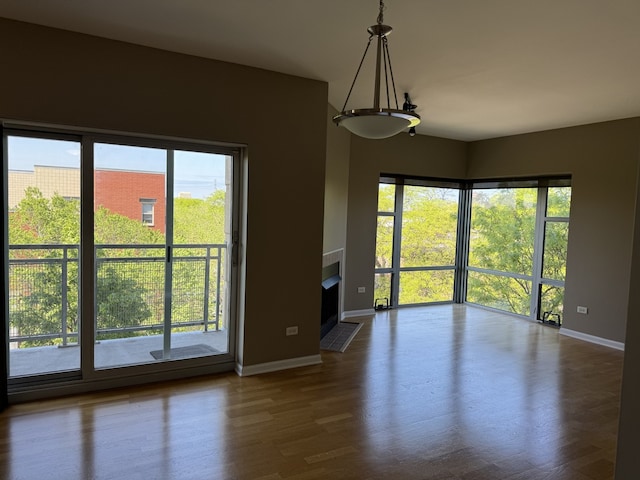 100 N Hermitage Ave Unit 409, Chicago, IL 60612 - unfurnished room featuring baseboards, a fireplace with flush hearth, and dark wood finished floors