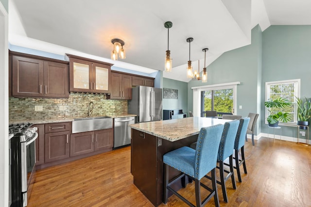 24608 George Washington Dr, Plainfield, IL 60544 - kitchen featuring a sink, appliances with stainless steel finishes, a breakfast bar, tasteful backsplash, and light wood-type flooring