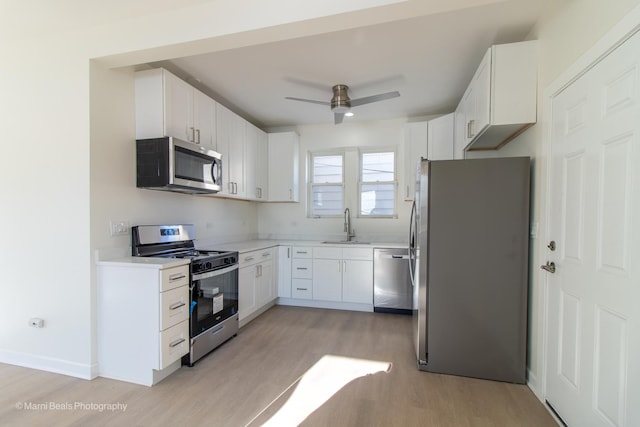 7341 S Maryland Ave, Chicago, IL 60619 - kitchen featuring stainless steel appliances, a sink, light wood-style floors, white cabinets, and ceiling fan