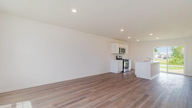 4203 High Point Ct, Joliet, IL 60436 - unfurnished living room featuring light wood-type flooring, recessed lighting, baseboards, and a sink