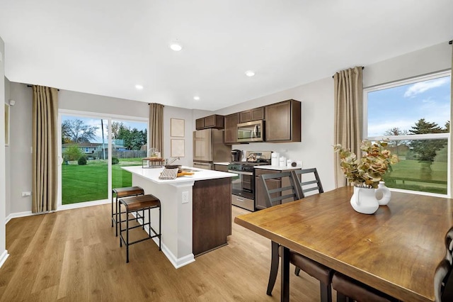4203 High Point Ct, Joliet, IL 60436 - kitchen featuring stainless steel appliances, a center island, a sink, dark brown cabinetry, and a kitchen bar