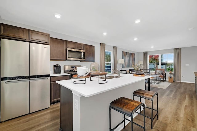 4203 High Point Ct, Joliet, IL 60436 - kitchen with appliances with stainless steel finishes, a sink, an island with sink, a breakfast bar, and dark brown cabinets