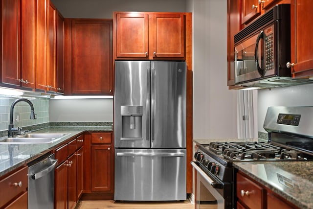 550 W Fulton St Unit 303, Chicago, IL 60661 - kitchen with stainless steel appliances, a sink, decorative backsplash, dark brown cabinets, and dark stone counters