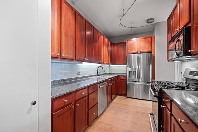 550 W Fulton St Unit 303, Chicago, IL 60661 - kitchen featuring stainless steel appliances, a sink, dark stone counters, light wood-type flooring, and tasteful backsplash