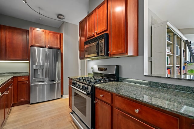 550 W Fulton St Unit 303, Chicago, IL 60661 - kitchen featuring appliances with stainless steel finishes, light wood-style flooring, dark stone countertops, and dark brown cabinets