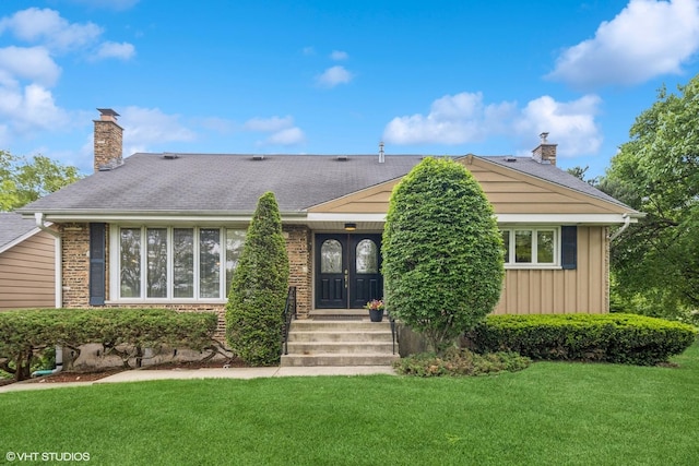 4N671 Petersdorf Rd, West Chicago, IL 60185 - view of front of home with a chimney, a front lawn, board and batten siding, and brick siding