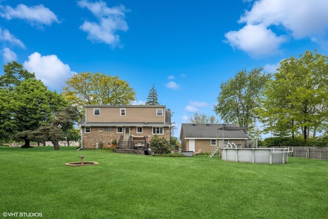 4N671 Petersdorf Rd, West Chicago, IL 60185 - back of house with an outdoor pool, brick siding, an outdoor fire pit, and a wooden deck