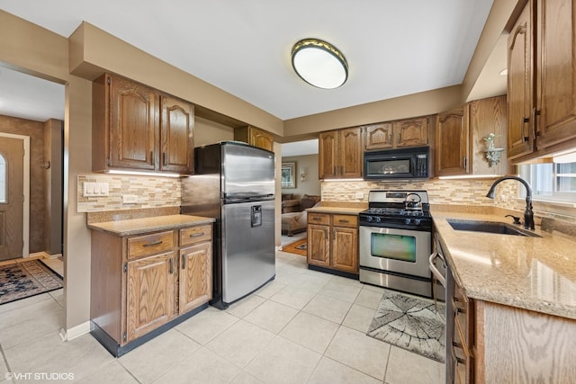 4N671 Petersdorf Rd, West Chicago, IL 60185 - kitchen with a sink, stainless steel appliances, light tile patterned floors, decorative backsplash, and brown cabinets