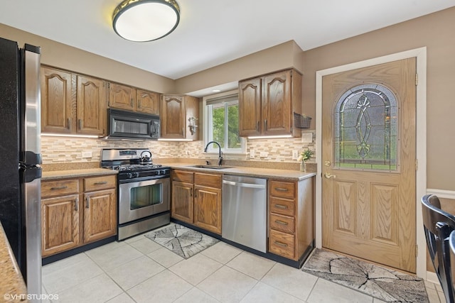 4N671 Petersdorf Rd, West Chicago, IL 60185 - kitchen featuring appliances with stainless steel finishes, a sink, decorative backsplash, light tile patterned flooring, and light countertops