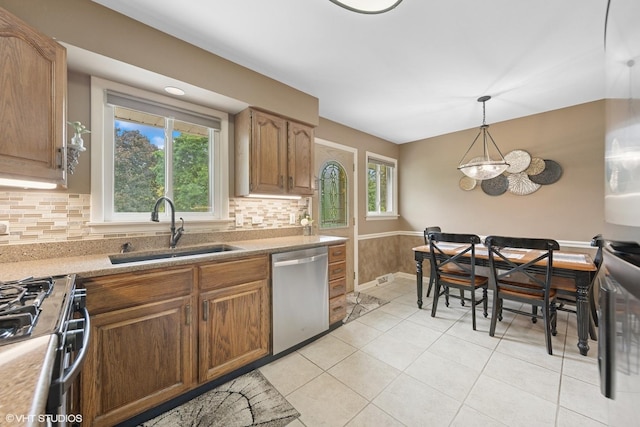 4N671 Petersdorf Rd, West Chicago, IL 60185 - kitchen with appliances with stainless steel finishes, a sink, a wainscoted wall, tasteful backsplash, and light tile patterned floors