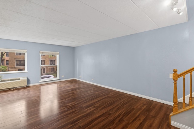 711 W Gordon Ter Unit 117, Chicago, IL 60613 - unfurnished room with wood finished floors, stairs, a wall mounted air conditioner, and baseboards