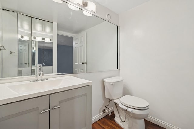 711 W Gordon Ter Unit 117, Chicago, IL 60613 - bathroom featuring wood finished floors, toilet, vanity, and baseboards