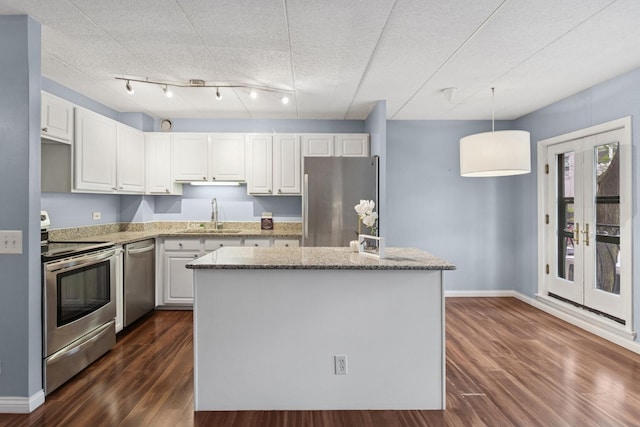 711 W Gordon Ter Unit 117, Chicago, IL 60613 - kitchen with appliances with stainless steel finishes, a sink, dark wood-style floors, white cabinetry, and french doors