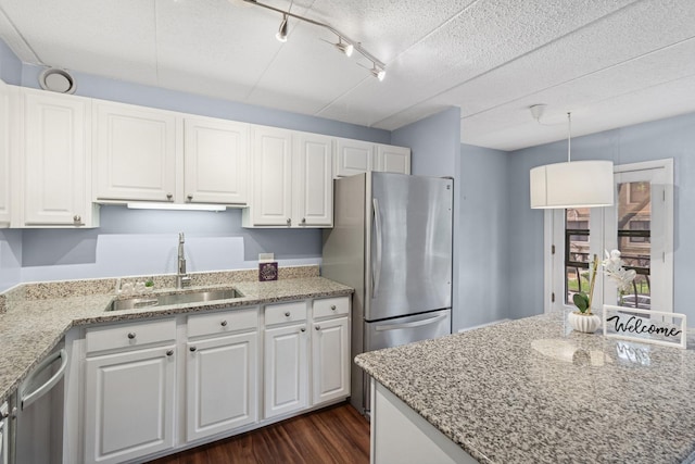 711 W Gordon Ter Unit 117, Chicago, IL 60613 - kitchen with a sink, stainless steel appliances, white cabinetry, dark wood-style flooring, and light stone counters