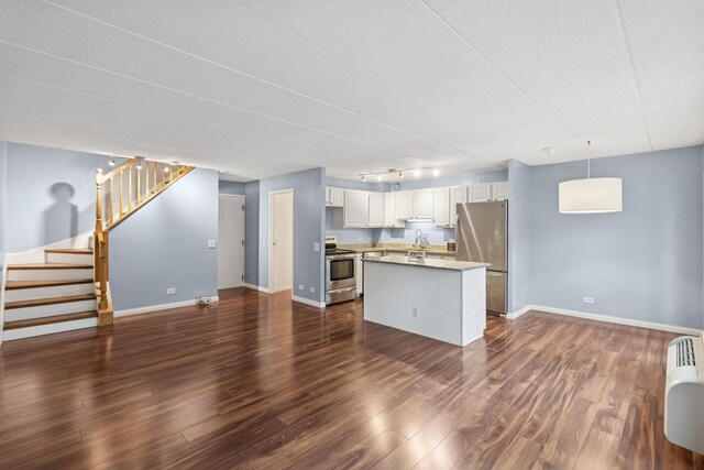 711 W Gordon Ter Unit 117, Chicago, IL 60613 - kitchen featuring appliances with stainless steel finishes, a sink, baseboards, dark wood-style flooring, and a kitchen island