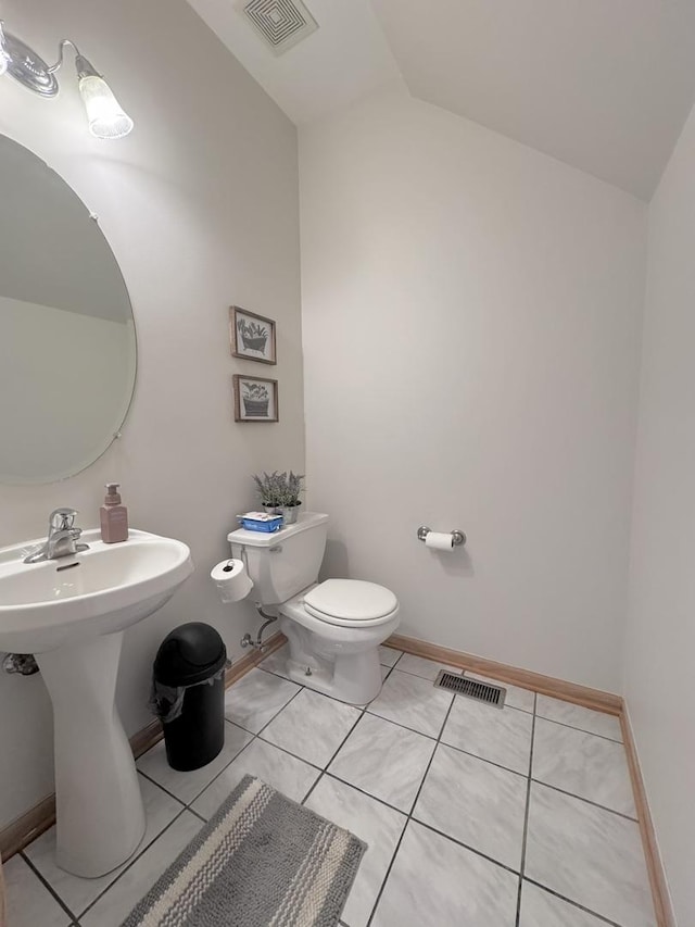 3854 Trading Post Ln, Joliet, IL 60435 - half bath featuring vaulted ceiling, toilet, tile patterned floors, baseboards, and a sink