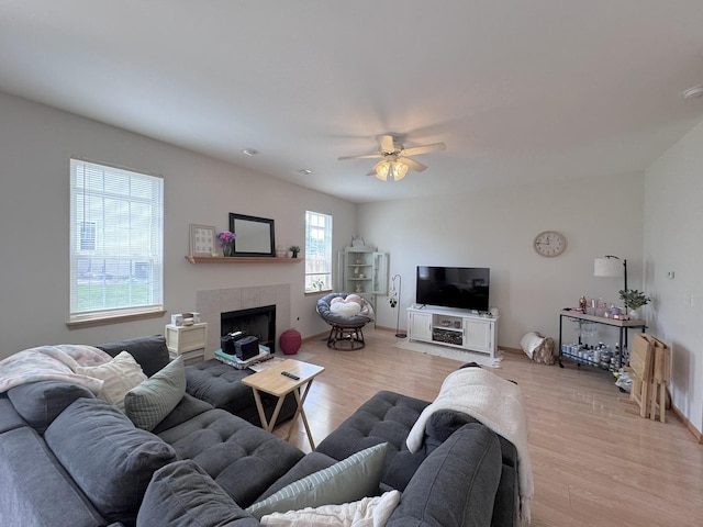 3854 Trading Post Ln, Joliet, IL 60435 - living room featuring light wood-type flooring, ceiling fan, a tile fireplace, and baseboards