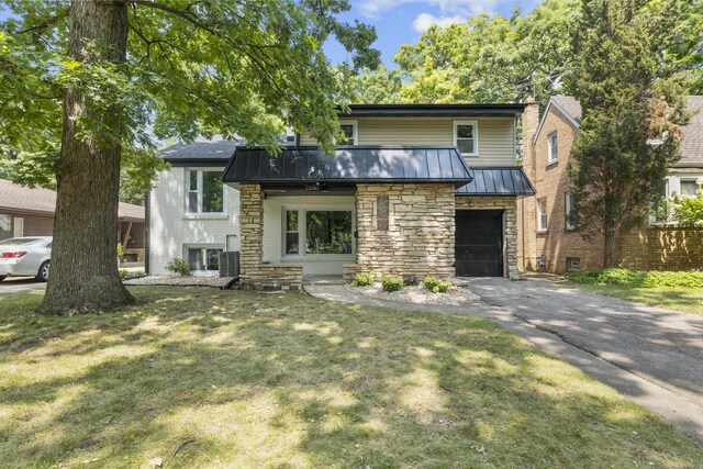 2200 W Crescent Ave, Park Ridge, IL 60068 - view of front facade featuring a standing seam roof, stone siding, driveway, a garage, and a front lawn