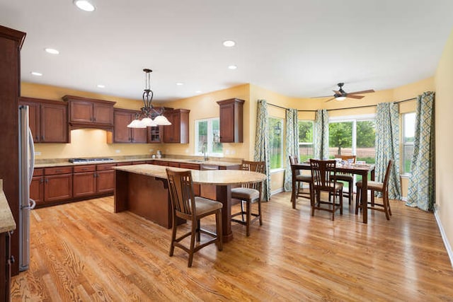 677 Slate Run, Elgin, IL 60124 - kitchen featuring freestanding refrigerator, plenty of natural light, a kitchen island, a breakfast bar, and recessed lighting