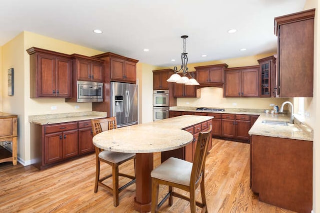 677 Slate Run, Elgin, IL 60124 - kitchen with a sink, stainless steel appliances, a kitchen island, a kitchen breakfast bar, and light wood-type flooring
