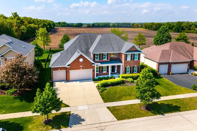 677 Slate Run, Elgin, IL 60124 - view of front facade featuring driveway, an attached garage, brick siding, and a front lawn