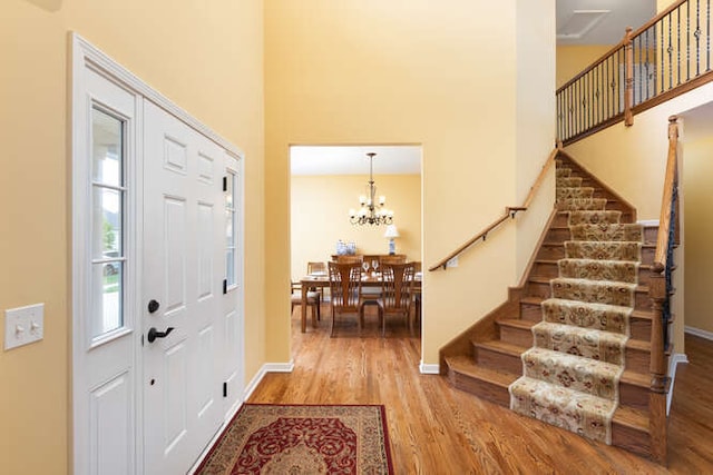 677 Slate Run, Elgin, IL 60124 - entryway featuring wood finished floors, a high ceiling, stairway, baseboards, and a chandelier