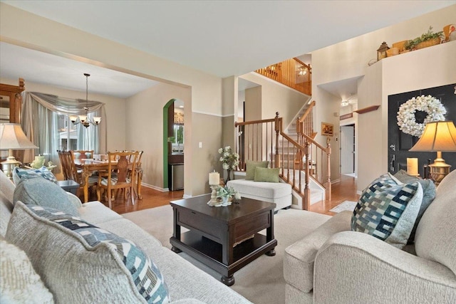 605 Acorn Ct, Antioch, IL 60002 - living room featuring a chandelier, wood finished floors, stairway, arched walkways, and baseboards