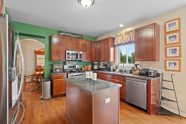 605 Acorn Ct, Antioch, IL 60002 - kitchen featuring appliances with stainless steel finishes, a sink, light wood-type flooring, dark countertops, and a kitchen island