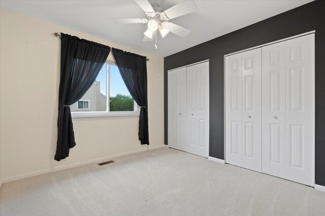 605 Acorn Ct, Antioch, IL 60002 - unfurnished bedroom with multiple closets, carpet flooring, baseboards, and ceiling fan
