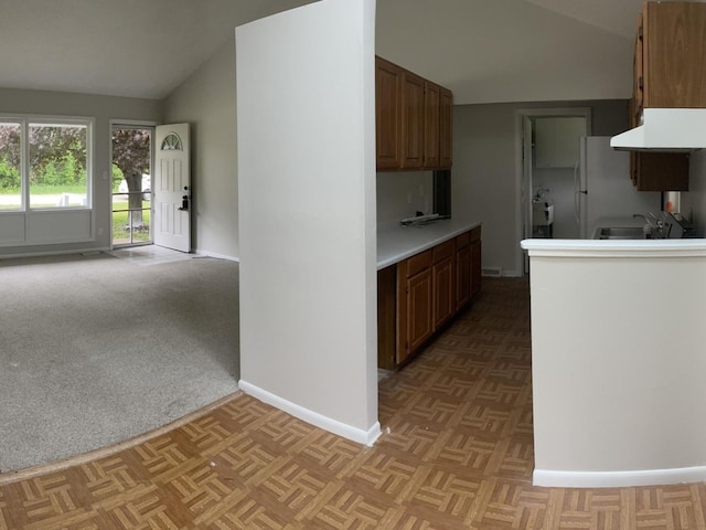 807 Finch Trl, Mchenry, IL 60051 - kitchen featuring lofted ceiling, under cabinet range hood, baseboards, freestanding refrigerator, and light countertops