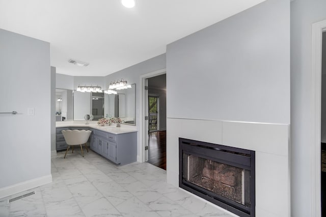 24161 Brancaster Dr, Naperville, IL 60564 - full bath featuring double vanity, baseboards, marble look tiles, and a fireplace
