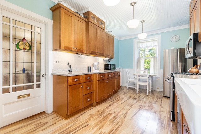 1006 S Jefferson St, Lockport, IL 60441 - kitchen with appliances with stainless steel finishes, brown cabinetry, crown molding, light wood-style floors, and tasteful backsplash