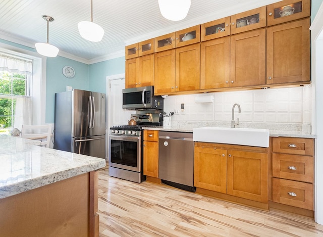 1006 S Jefferson St, Lockport, IL 60441 - kitchen featuring stainless steel appliances, a sink, brown cabinetry, ornamental molding, and light wood-style flooring