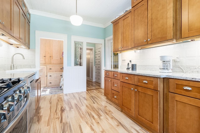 1006 S Jefferson St, Lockport, IL 60441 - kitchen with gas range, brown cabinets, light wood-type flooring, crown molding, and decorative backsplash