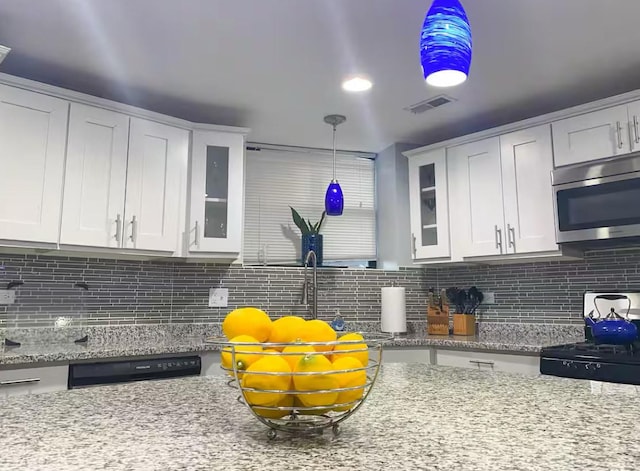 4148 S King Dr Unit G3, Chicago, IL 60653 - kitchen featuring stainless steel microwave, gas range oven, white cabinetry, and backsplash