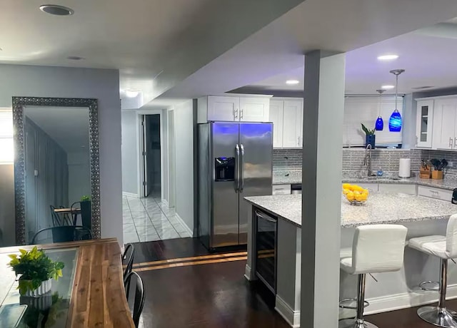 4148 S King Dr Unit G3, Chicago, IL 60653 - kitchen with stainless steel fridge, a sink, baseboards, white cabinets, and recessed lighting