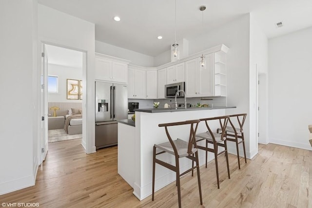 2505 W Potomac Ave Unit 3W, Chicago, IL 60622 - kitchen with appliances with stainless steel finishes, open shelves, dark countertops, white cabinetry, and a peninsula