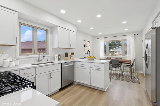 3838 Emerson Dr, Schiller Park, IL 60176 - kitchen with appliances with stainless steel finishes, a sink, a peninsula, white cabinetry, and recessed lighting