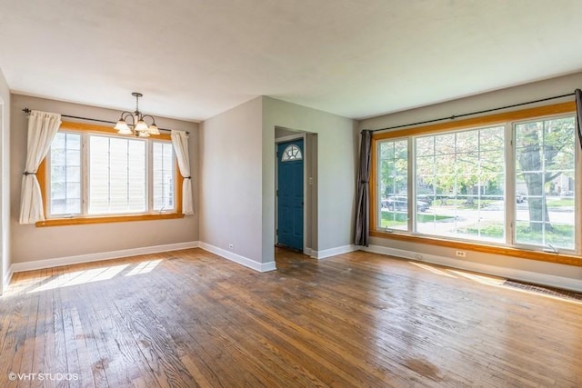 2140 Cedar Ct, Glenview, IL 60025 - empty room with a chandelier, baseboards, plenty of natural light, and wood finished floors